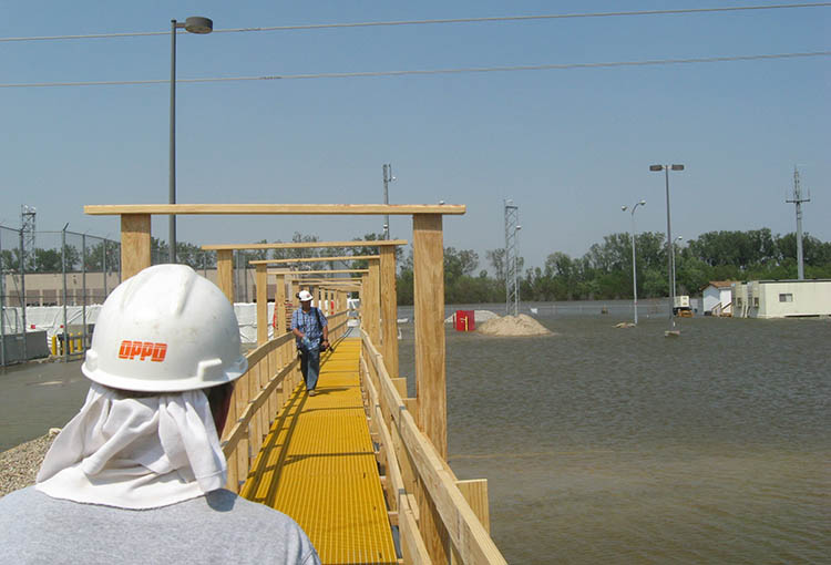 Workers had to use an elevated walkway to traverse over the floodwaters.