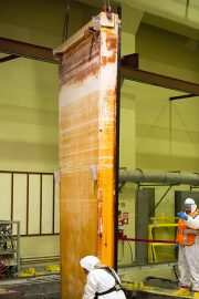 In the auxiliary building, Josh Wheeler, in the orange vest, signals to the crane operator to place the spent-fuel pool sluice gate into position.