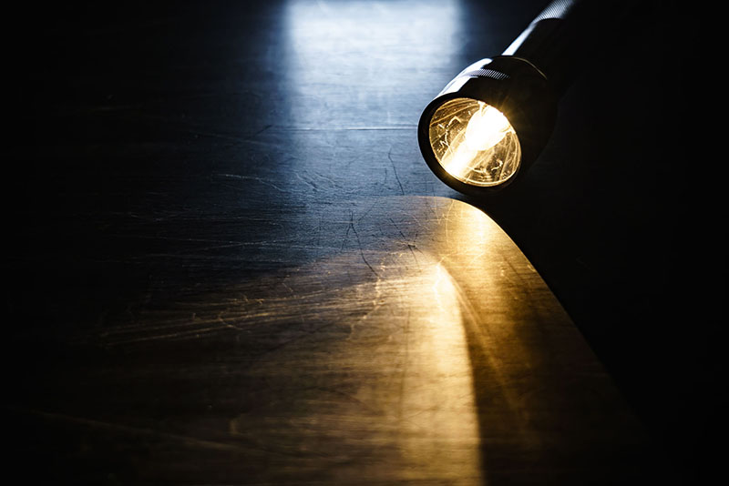 flashlight lying on a floor in the dark, what should you do in a power outage