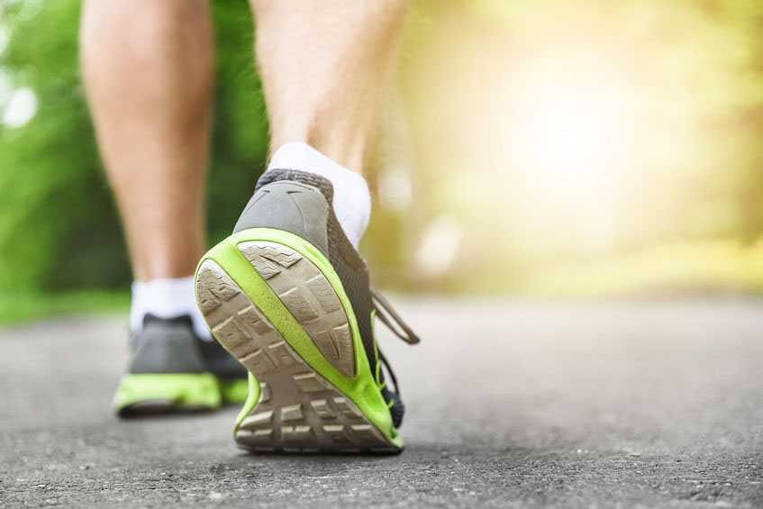 Athlete runner feet running on road.