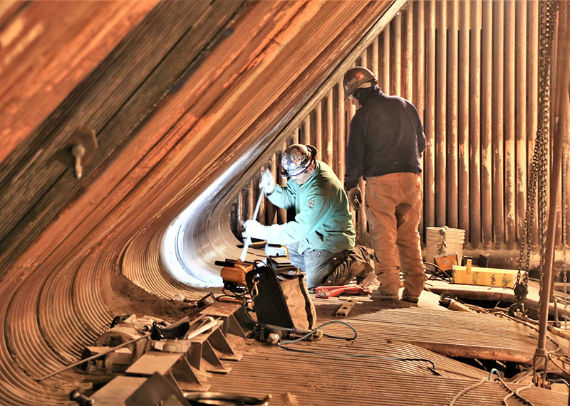 Workers replace tubing at OPPD's Nebraska City power plant during a maintenance outages at fossil plants in 2019