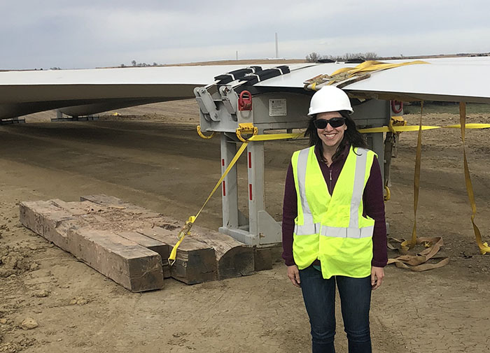 Courtney Kennedy, manager of alternative energy resources for OPPD, standing next to a wind turbine blade
