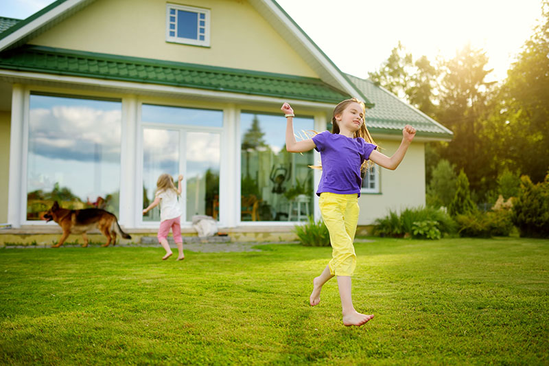 Cute little girl having fun on a grass on the backyard on sunny summer evening summer safety tips