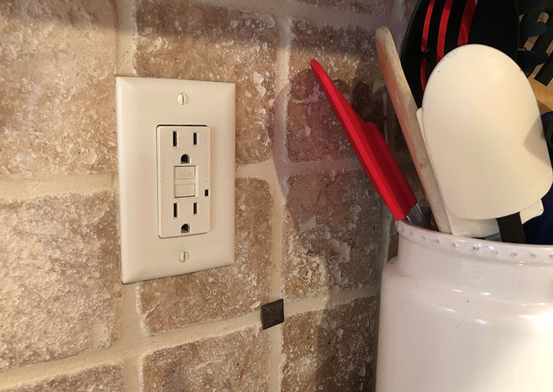 A ground fault circuit interrupter on an electrical outlet in a kitchen.