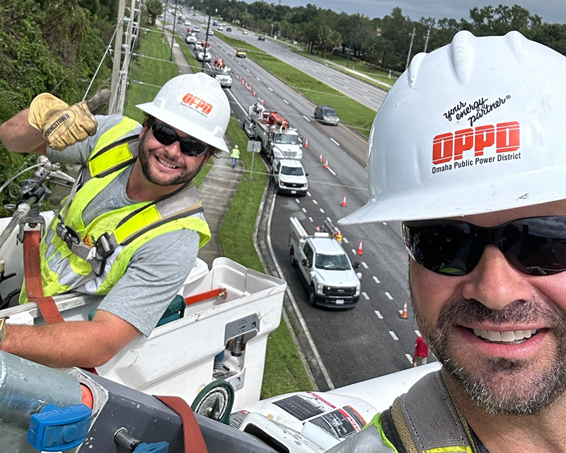 OPPD line workers who volunteered to serve on a mutual aid are shown working on lines alongside a Florida highway.