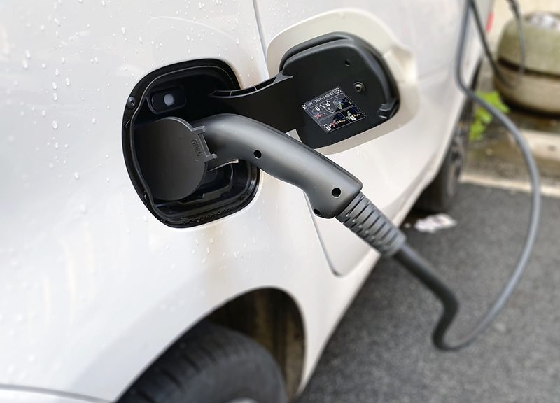 A charger is shown plugged into a electric vehicle. The federal EV tax credit program expires September 30.