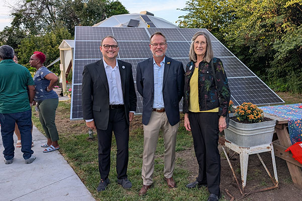 Britton Gabel, Cliff Fleener and Mary Spurgeon stand in front of a solar panel at City Sprouts Community Garden.