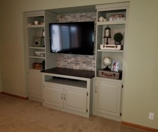 The updating of this entertainment center is another home improvement Shane Hanson tackled at home. It includes shelves and cabinets built into the wall and a nook for a flat screen television.