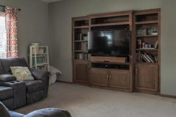 The is what the entertainment center in Hanson's house looked like before he updated it. The wood is a natural-looking stain before. This home improvement project involved reconfiguring the unit's shelves and spaces and painting the wood.