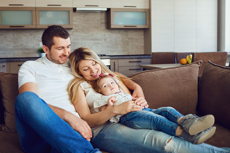 A family is shown sitting on a sofa. Don & Millie's Caring & Sharing program is supporting OPPD's Energy Assistance Program for two days this month.