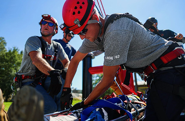 The team secures a fake "patient" during an exercise. The rescue teams focused on safety and patient care.