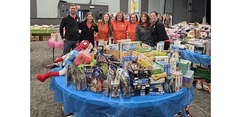 OPPD employees pose for a photo in front of a table of toys.