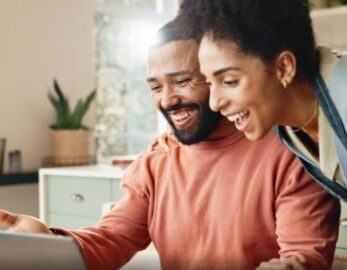 A couple looks at their laptop screen.