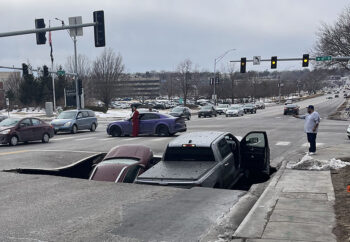 An SUV and a pickup fell into the sinkhole that opened at the intersection of Pacific and 67th streets.