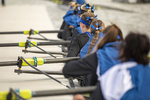 Rowers sit in their boat preparing to leaving the docking area to practice.