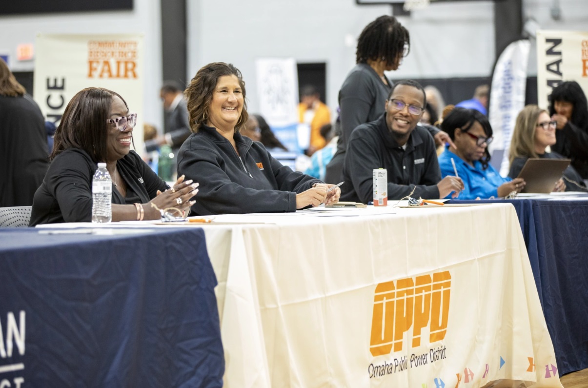 OPPD and M.U.D. representatives sit at a table during the community resource fair in North Omaha.