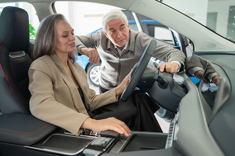 A couple looks at an electric vehicle at a dealership. OPPD can help you decide if an EV is right for you.