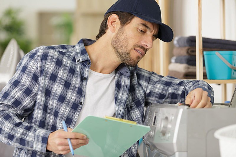 A service work inspects an appliance.